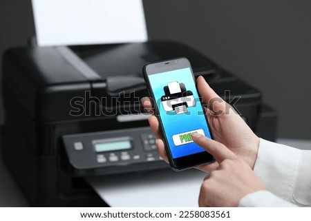 Man using printer management application on mobile phone indoors, closeup and space for text