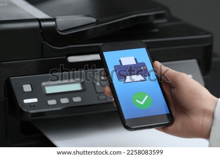 Man using printer management application on mobile phone indoors, closeup