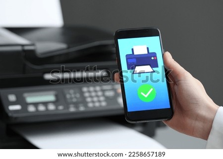 Man using printer management application on mobile phone indoors, closeup and space for text