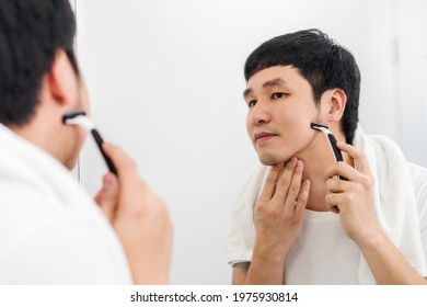 Man Using Razor To Shaving His Face Without Foam, Dry Shave In The Bathroom Mirror