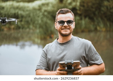 Man using remote to fly drone in nature with sunglasses