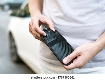 Man Using RFID Protection Pouch For Car Key, Anti-theft RFID Key Pouch.