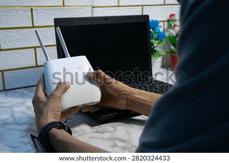 The man is using a router, high-speed internet connection, network bandwidth technology, and speed optimization.