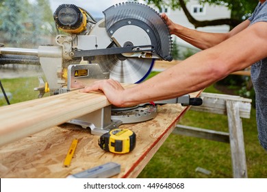 Man using saw to cut wood