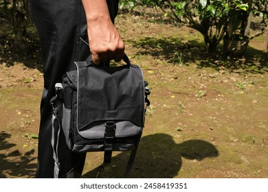 Man USing a Small Shoulder Camera Bag