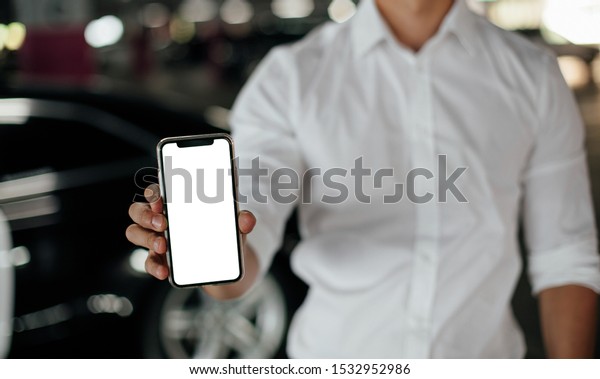 Man using smart phone on parking lot. Blank\
screen of smartphone on\
parking