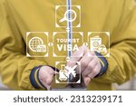 Man using smart phone and virtual touch screen sees inscription: TOURIST VISA. Traveling abroad concept. Visa application approving and insurance certificate processing.