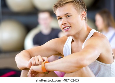 Man Using Smart Watch While Looking Away In Gym