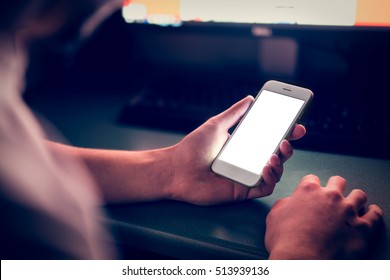 Man using smartphone with blank screen in dark room - Powered by Shutterstock