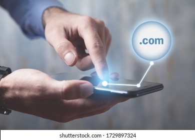 Man Using Smartphone With A .com Domain Button.