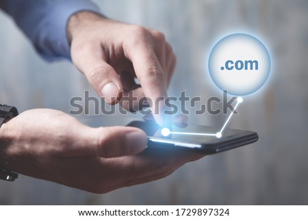 Man using smartphone with a .com domain button.