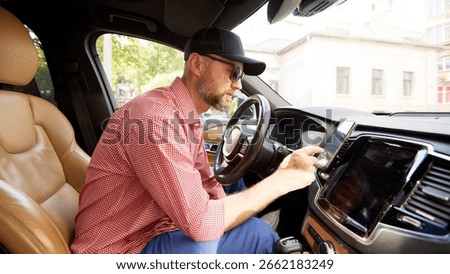 Man using smartphone inside a car while sitting on driver's seat
