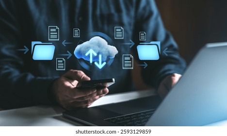 Man using smartphone and laptop with cloud storage icons, folders, and arrows representing online data transfer. Digital network technology concept