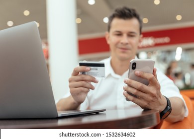 Man using smartphone and laptop computer for online shopping . Credit card