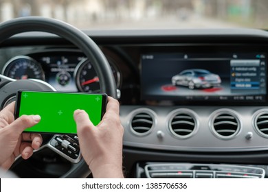 Man using smartphone on the background of luxury class car dashboard