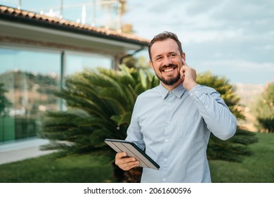 Man Using Smartphone Outdoor. Portrait Of Young Businessman Using Mobile Phone While Looking Away On The Street. Thoughtful Business Man In Blue Formal Clothing Using Cellphone Outside 