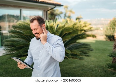 Man Using Smartphone Outdoor. Portrait Of Young Businessman Using Mobile Phone While Looking Away On The Street. Thoughtful Business Man In Blue Formal Clothing Using Cellphone Outside 