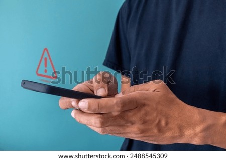 Man using a smartphone with red triangle caution warning sign for notification error, restricted content or maintenance concept.