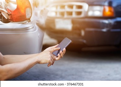 
Man using smartphone at roadside after traffic accident