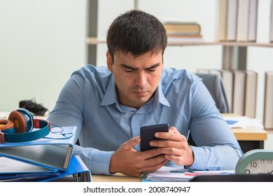 Man using smartphone sitting in office online internet technology