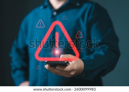 Man using smartphone with warning sign.Notification error and virus detection spyware. Emergency warning alert alarm on smartphone. Data network protection. Virus alarm.