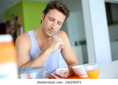 Man using smartphone while having breakfast - Powered by Shutterstock - Get 15% off with code: PIKWIZARD15