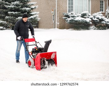 Man using a snow blowing machine, Canada