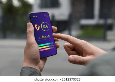 Man using step counting app on smartphone outdoors, closeup