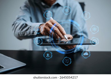 man using stylus on tablet with futuristic tech icons. Concept of AI, innovation, digital transformation, smart technology, and real people in modern workspace.

