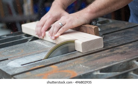 Man Using a Table Saw to cut a 2 by 4 of Wood (Sawdust Flying) - Shutterstock ID 496802935