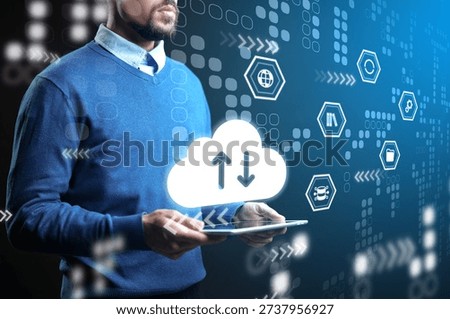 Man using tablet for cloud data exchange in digital environment with various icons
