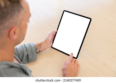 Man Using Tablet Computer, Empty White Screen Mockup, Over The Shoulder View