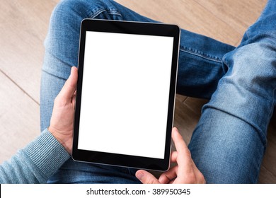 Man using tablet computer while sitting on a wooden floor. View from above. Clipping path included.