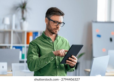 Man Using Tablet In Office, Focused On Work, Professional Concept