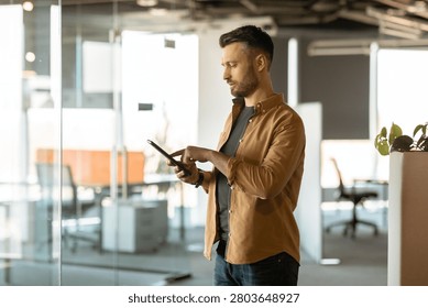 Man Using Tablet In Office, Focused On Digital Device, Business Concept