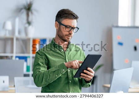 Man Using Tablet In Office, Focused On Work, Professional Concept