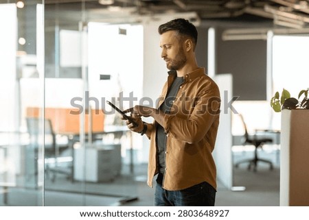 Man Using Tablet In Office, Focused On Digital Device, Business Concept