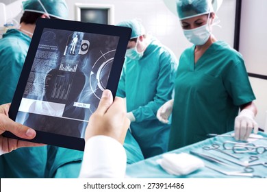 Man using tablet pc against medical interface on xray - Powered by Shutterstock