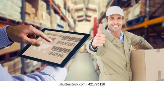 Man using tablet pc against shelves with boxes in warehouse