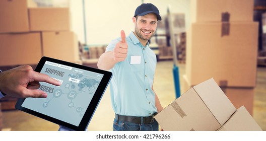 Man using tablet pc against boxes on trolley in warehouse
