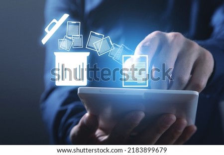 Man using tablet. Trash can and files. Delete files