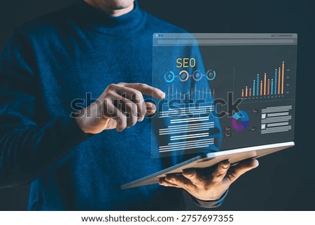 Man using tablet with virtual screen displaying SEO analytics, data charts, and marketing performance metrics. Concept of search engine optimization, business growth, data analysis, and digital marketing strategy.