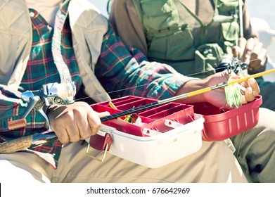 Man Using Tackle Box And Preparing Fishing Pole