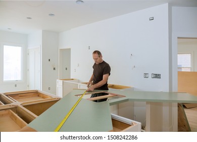 Man using tape measure for measuring size of wooden countertop in modern kitchen material design for home improvement.