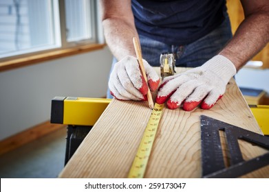 A Man Using A Tape Measure And Pencil