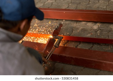 Man using torch cut metal plate in workshop - Powered by Shutterstock