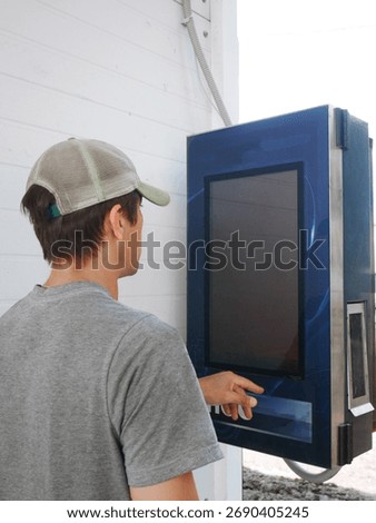 Man using touchscreen interface outdoor machine