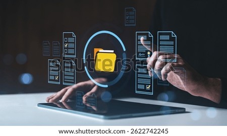 Man using touchscreen tablet with digital folder and document icons, modern interface style, on dark background, concept of data organization