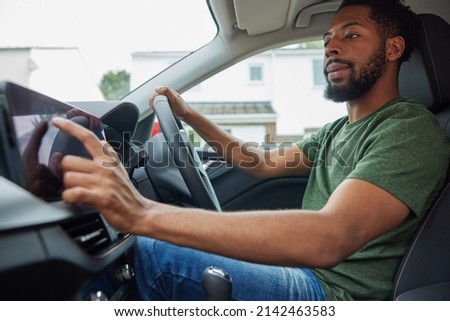 Man Using Touchscreen Whilst Driving Car