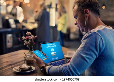 Man using two factor authentication on laptop computer and mobile phone